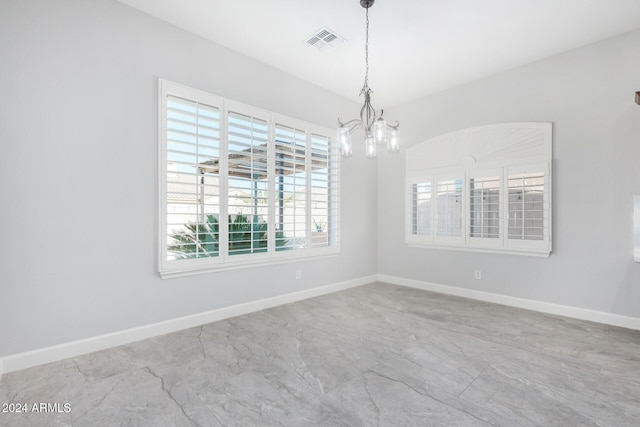 empty room with an inviting chandelier and a wealth of natural light