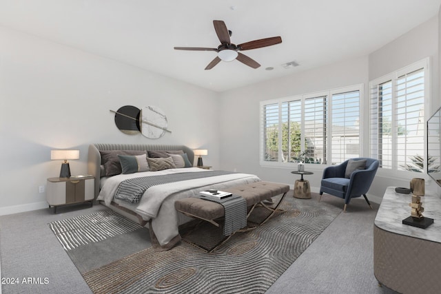 bedroom with multiple windows, ceiling fan, and light colored carpet