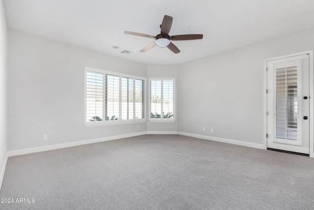 carpeted spare room featuring ceiling fan