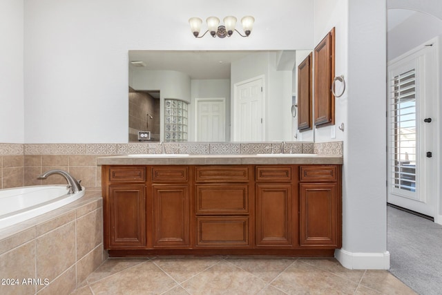 bathroom with tile patterned floors, vanity, and tiled bath