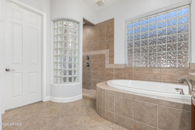 bathroom featuring tile patterned flooring and shower with separate bathtub