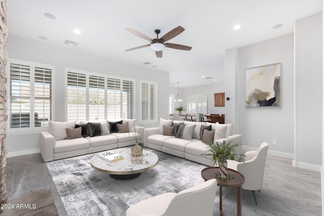 living room featuring ceiling fan with notable chandelier