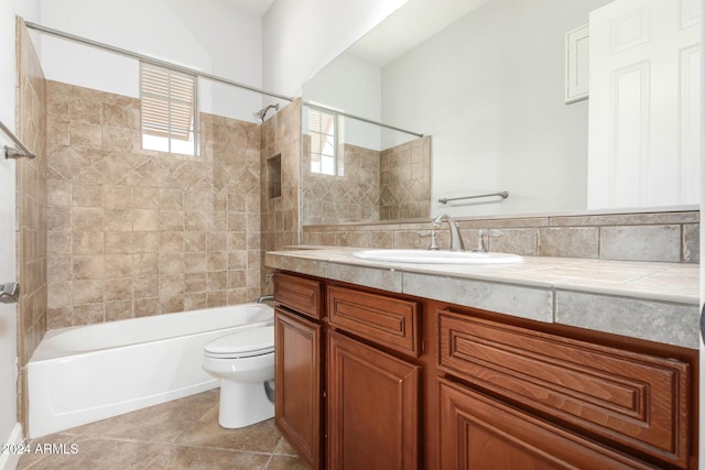 full bathroom featuring tile patterned flooring, vanity, toilet, and tiled shower / bath