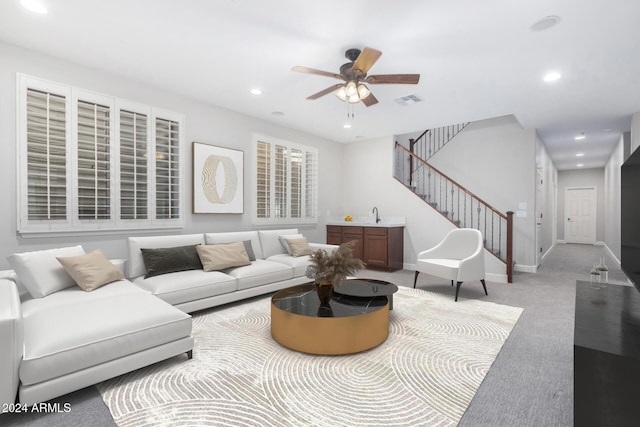 carpeted living room with ceiling fan