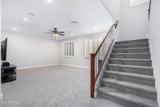 stairway with carpet and ceiling fan