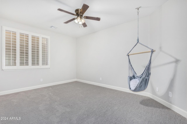 carpeted spare room with ceiling fan