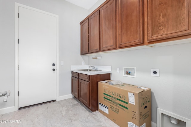 clothes washing area with electric dryer hookup, hookup for a washing machine, sink, and cabinets