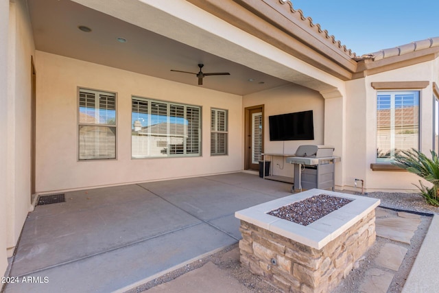 view of patio with ceiling fan, area for grilling, and an outdoor fire pit