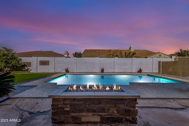 pool at dusk with a fire pit