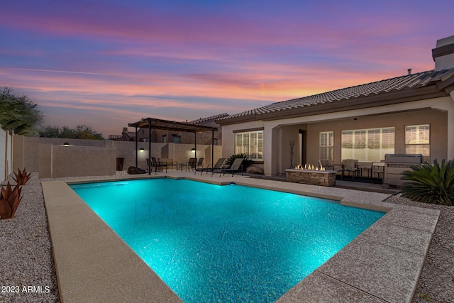 pool at dusk featuring a pergola, an outdoor fire pit, and a patio