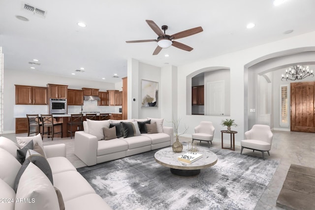 living room featuring ceiling fan with notable chandelier