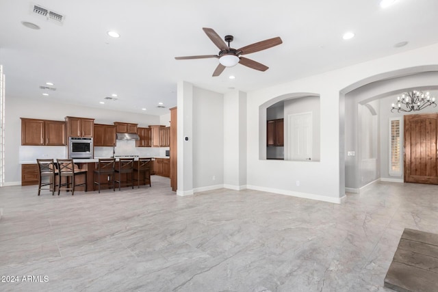 living room with ceiling fan with notable chandelier