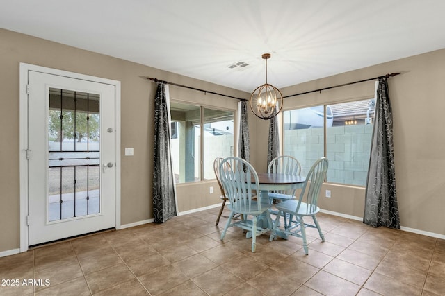 tiled dining area featuring visible vents, plenty of natural light, and an inviting chandelier