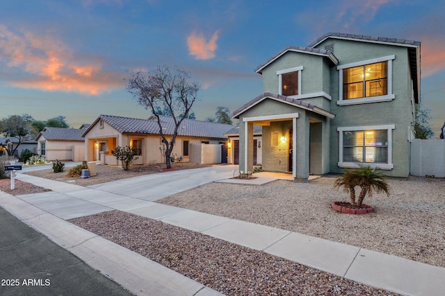 view of front of property featuring concrete driveway, a tiled roof, and stucco siding