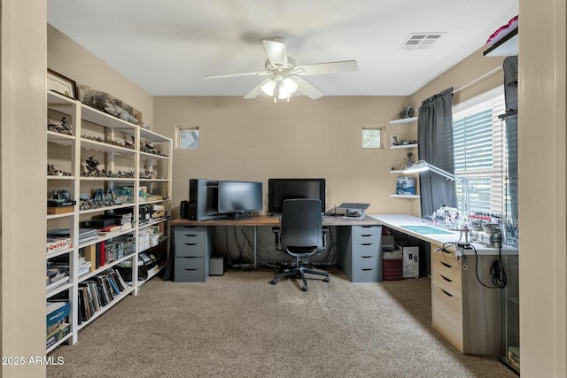 home office featuring carpet flooring, a ceiling fan, and visible vents