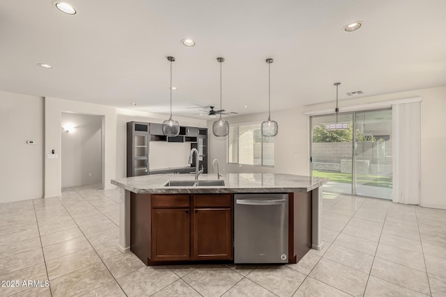 kitchen with ceiling fan, an island with sink, sink, and pendant lighting