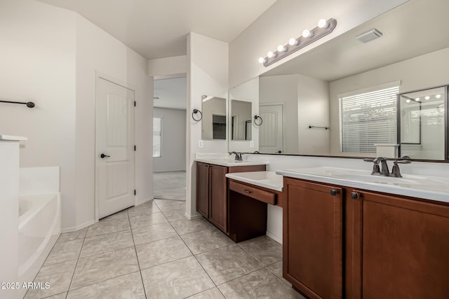 bathroom with a tub to relax in, vanity, and tile patterned floors