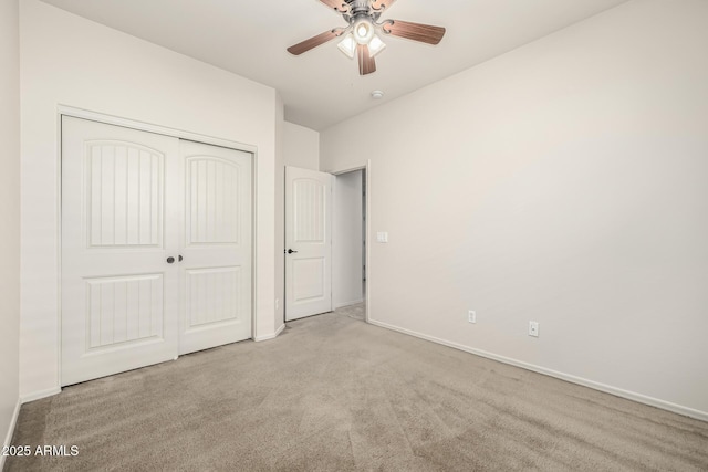 unfurnished bedroom featuring ceiling fan, a closet, and light carpet