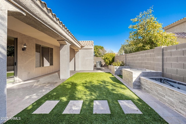 view of yard with central AC unit and a patio