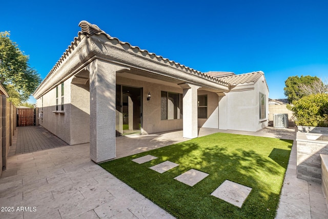 rear view of house with a patio area and a lawn