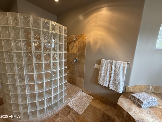 bathroom featuring stone tile floors and walk in shower