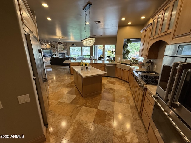 kitchen featuring visible vents, a sink, open floor plan, a peninsula, and appliances with stainless steel finishes