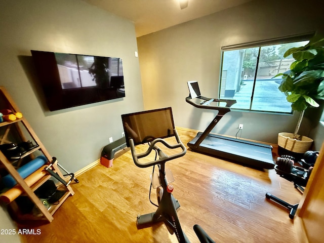 workout area featuring baseboards and wood finished floors