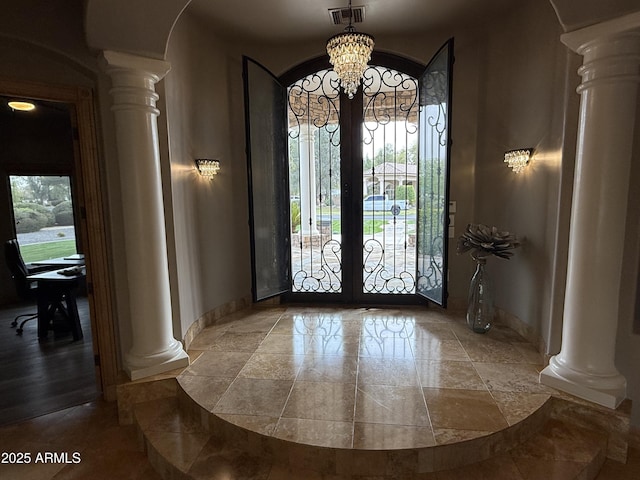 foyer entrance with decorative columns, french doors, visible vents, and a healthy amount of sunlight