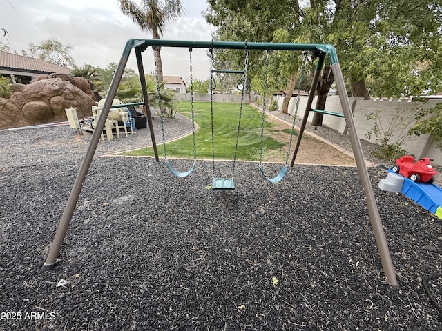 community jungle gym with a lawn and fence