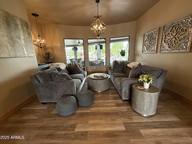 living room with baseboards, an inviting chandelier, and wood finished floors