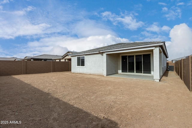 back of property with cooling unit and a patio