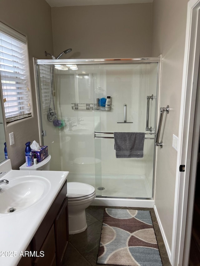 bathroom with a stall shower, tile patterned flooring, vanity, and toilet