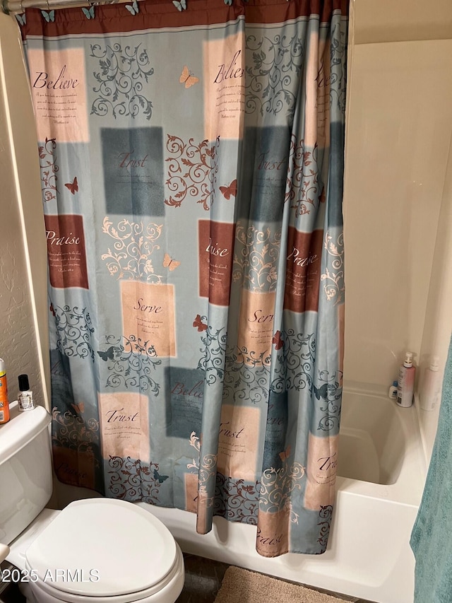 bathroom featuring toilet and shower / tub combo with curtain