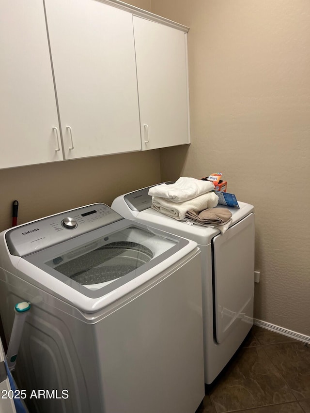 laundry area featuring cabinet space, baseboards, and washer and dryer