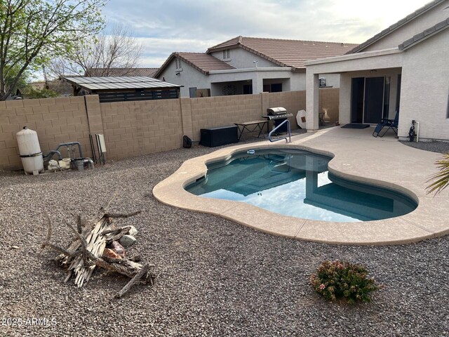 view of swimming pool featuring area for grilling, a patio area, and a fenced backyard