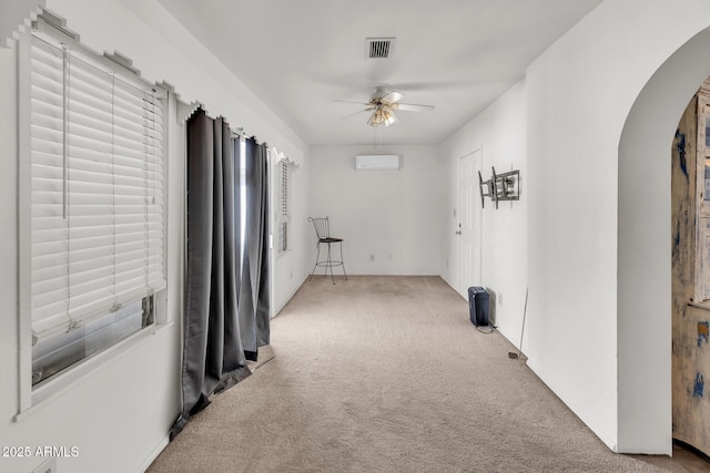 10806 N 114th Ave, Youngtown, AZ 85363 - carpeted spare room featuring visible vents, arched walkways, an AC wall unit, and a ceiling fan