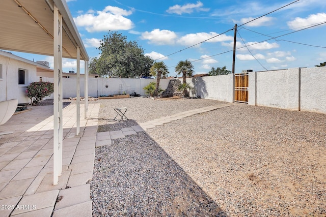 10806 N 114th Ave, Youngtown, AZ 85363 - view of yard featuring a gate, fence private yard, and a patio area