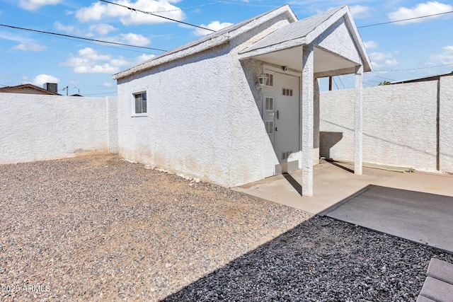 10806 N 114th Ave, Youngtown, AZ 85363 - view of side of property with stucco siding, a fenced backyard, and a patio area