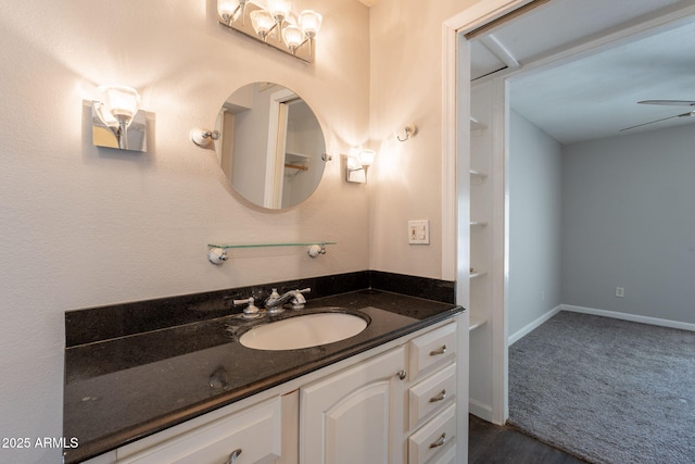 bathroom with ceiling fan, baseboards, and vanity