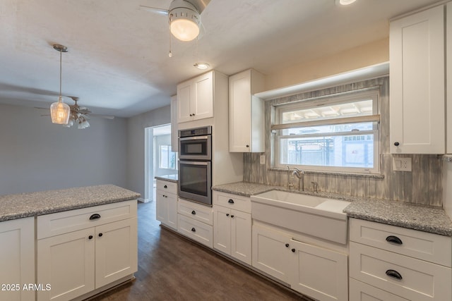 kitchen featuring white cabinets, dark wood-style floors, ceiling fan, and a sink