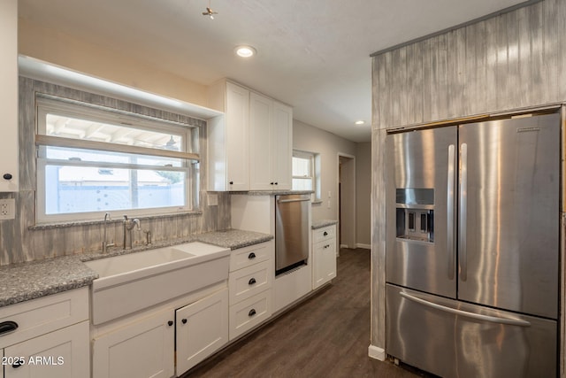 kitchen with stainless steel fridge with ice dispenser, recessed lighting, oven, and light stone countertops