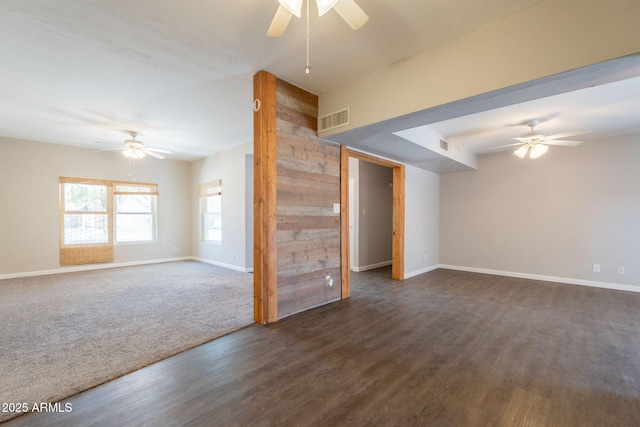 unfurnished living room featuring visible vents, baseboards, ceiling fan, and dark wood-type flooring