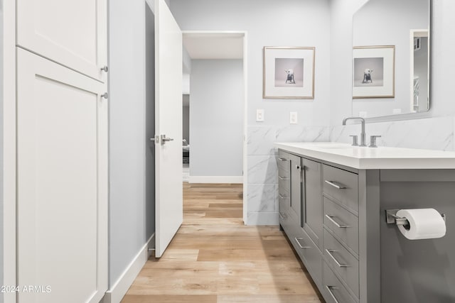 bathroom featuring vanity, hardwood / wood-style flooring, and tile walls