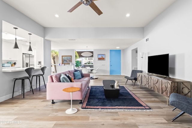 living room with ceiling fan and light hardwood / wood-style floors