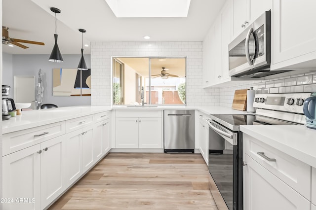 kitchen with decorative backsplash, sink, light hardwood / wood-style floors, and appliances with stainless steel finishes