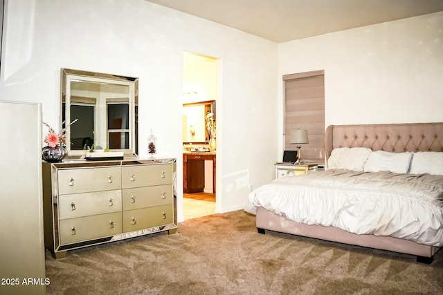 bedroom with ensuite bathroom and carpet floors