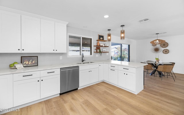 kitchen with decorative light fixtures, white cabinetry, dishwasher, sink, and kitchen peninsula