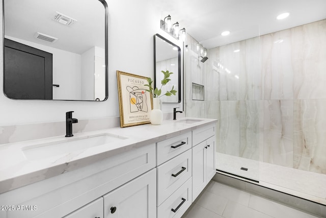 bathroom with vanity, tile patterned flooring, and tiled shower