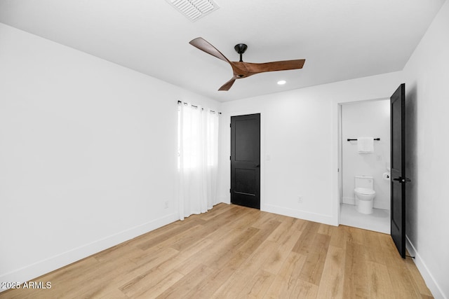 unfurnished bedroom featuring ceiling fan, ensuite bath, and light wood-type flooring