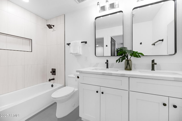 full bathroom featuring tiled shower / bath combo, vanity, and toilet